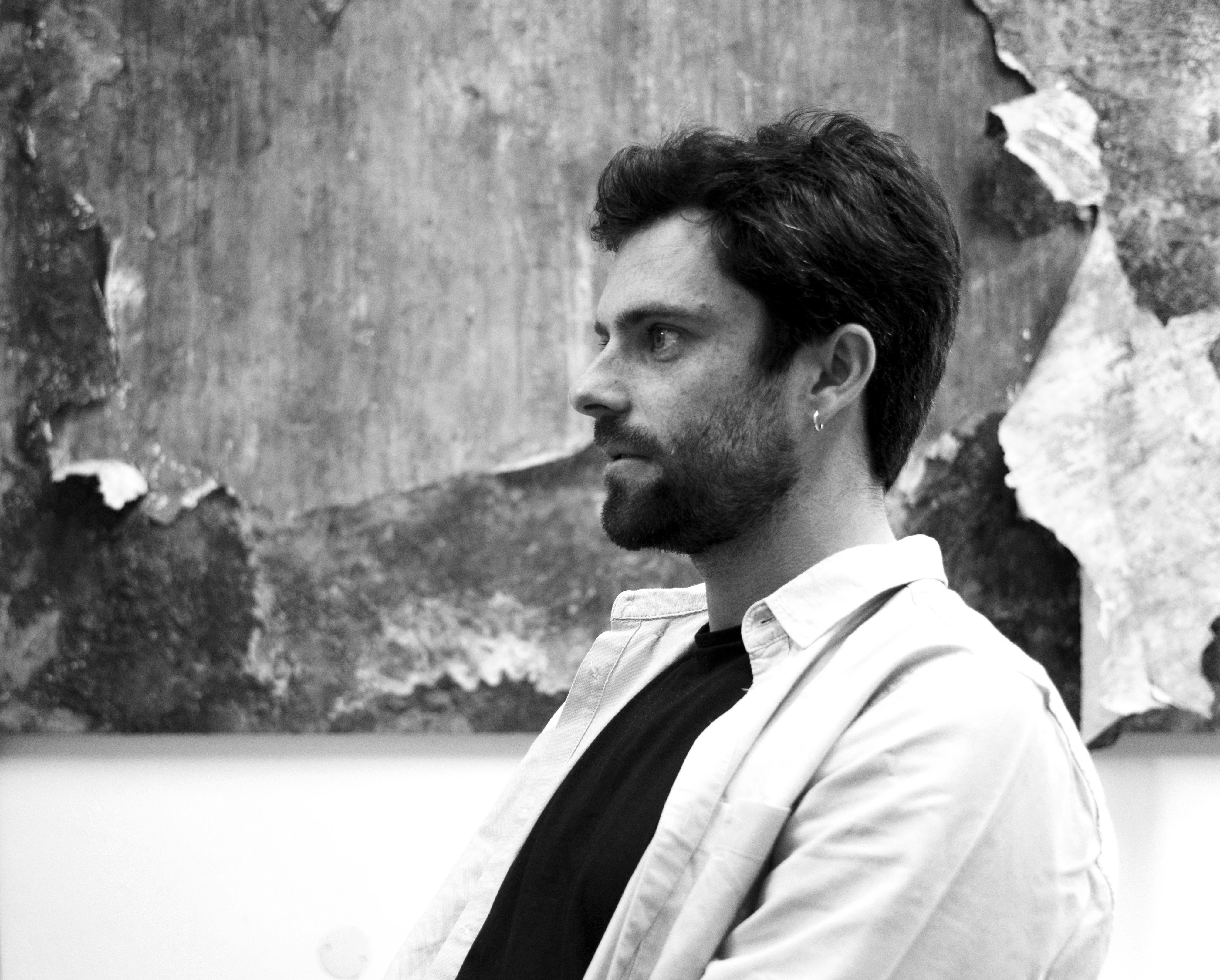Black-and-white portrait of Filipe Cortez in front of a marked wall surface